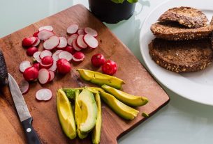 banana fruit and bread on brown wooden chopping board